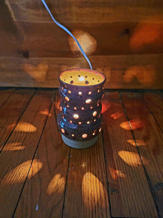 Decorative lantern with holes on a wooden surface