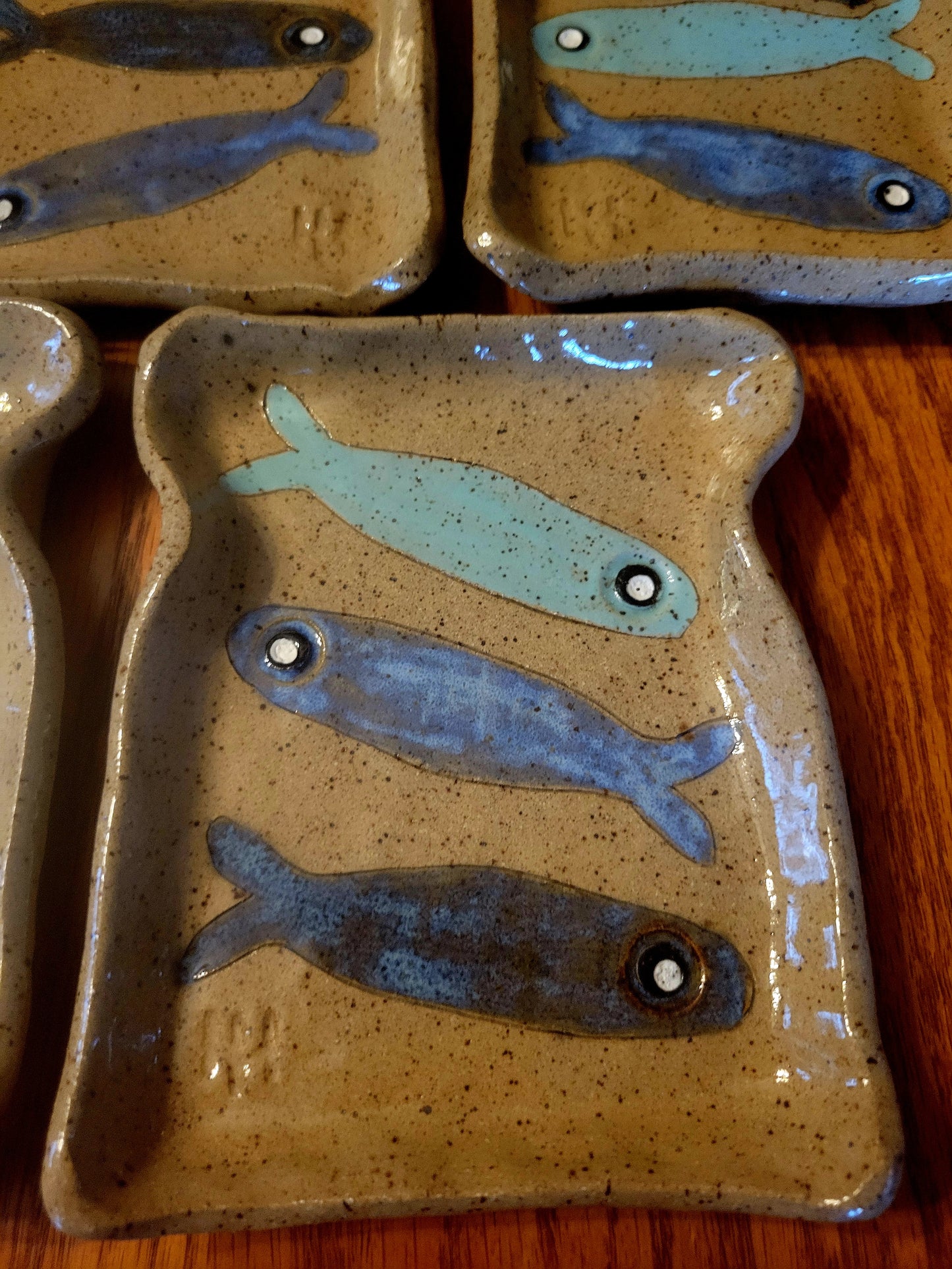 Ceramic plates with fish designs on a wooden surface