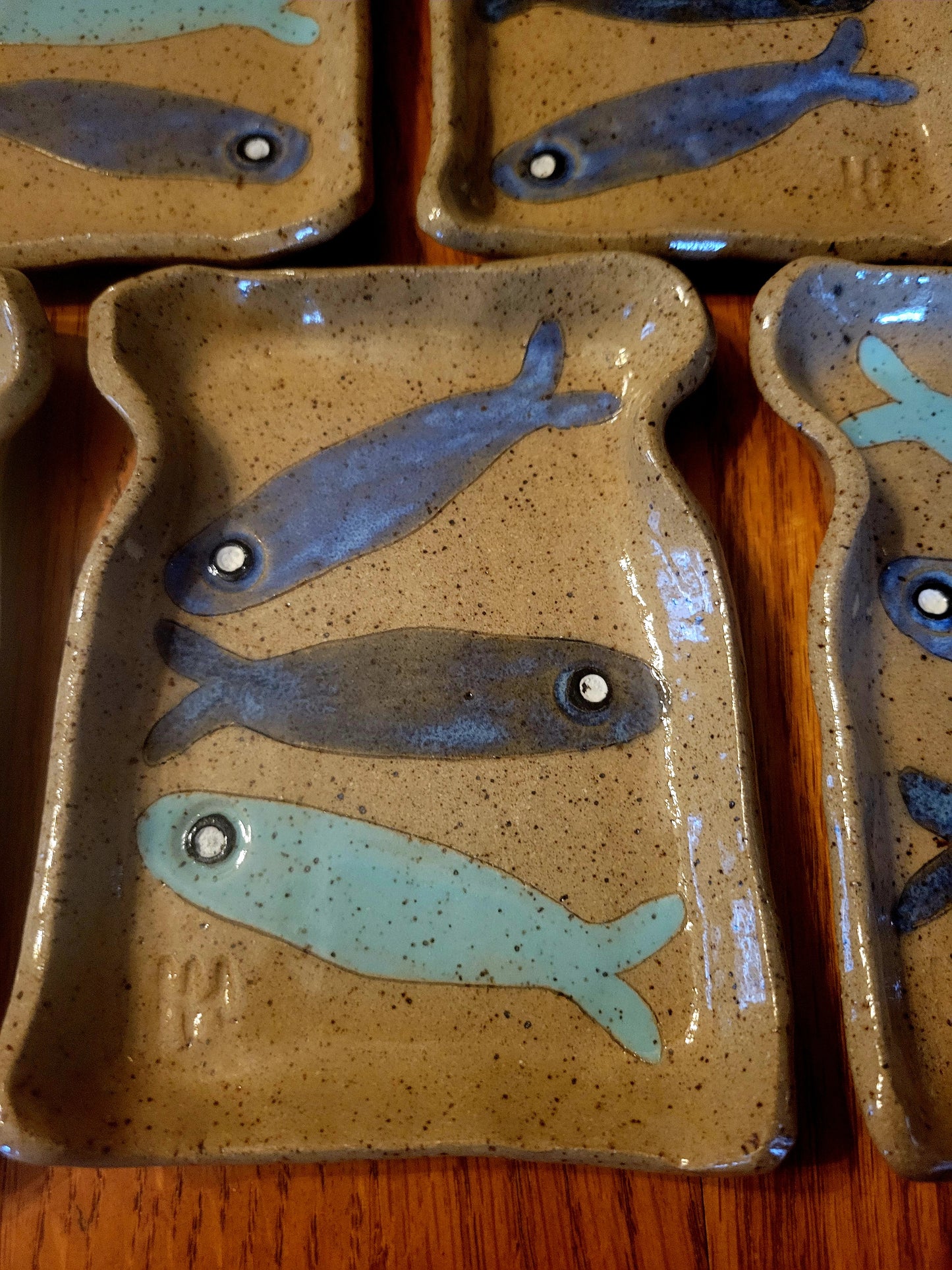 Ceramic plates with fish designs on a wooden surface
