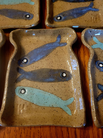 Ceramic plates with fish designs on a wooden surface
