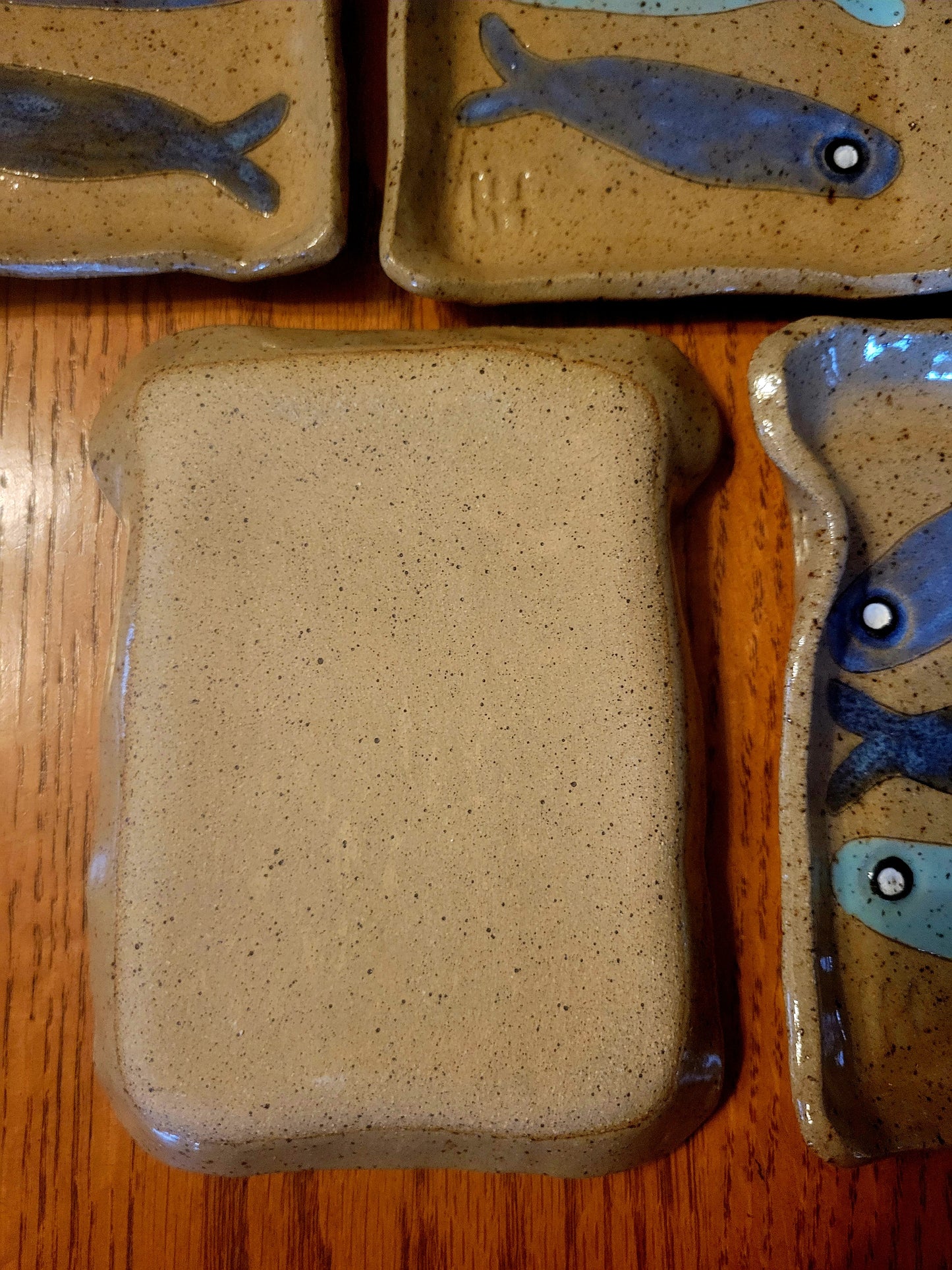 Set of ceramic plates with fish designs on a wooden surface