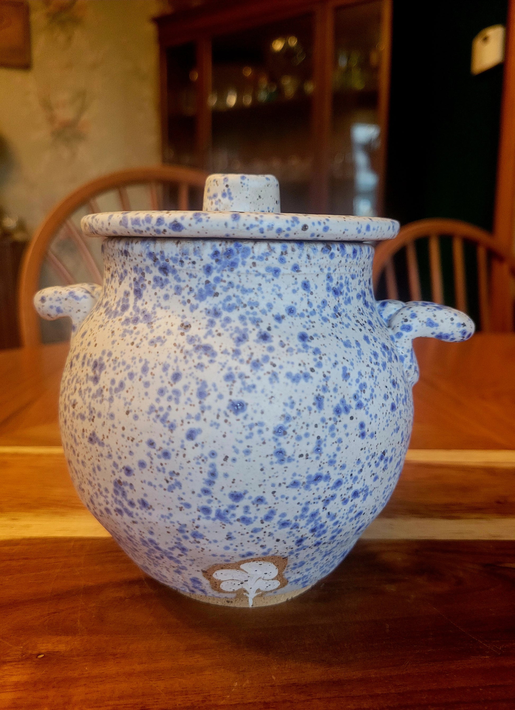 Speckled blue ceramic pot on a wooden surface