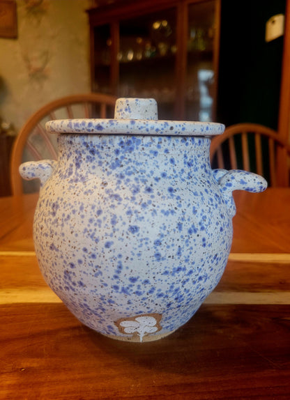 Speckled blue ceramic pot on a wooden surface