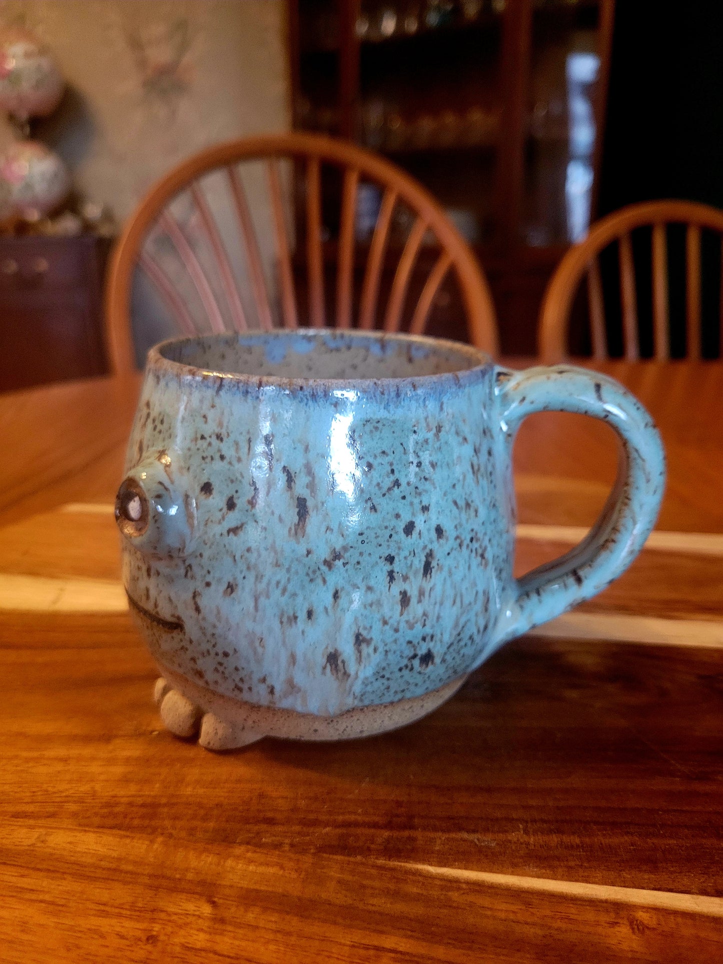 Speckled blue mug with a handle on a wooden table