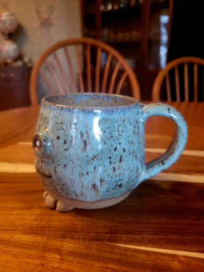Speckled blue mug with a handle on a wooden table