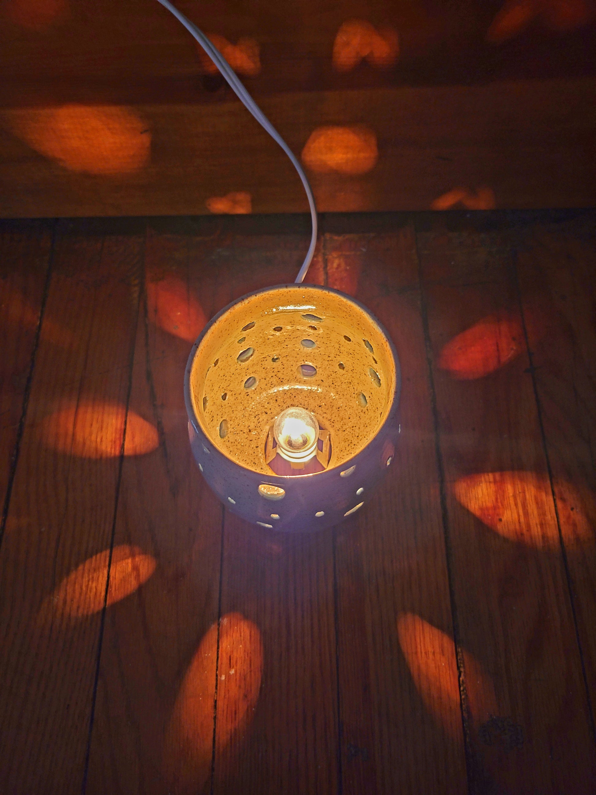 Decorative lamp with a textured shade on a wooden surface