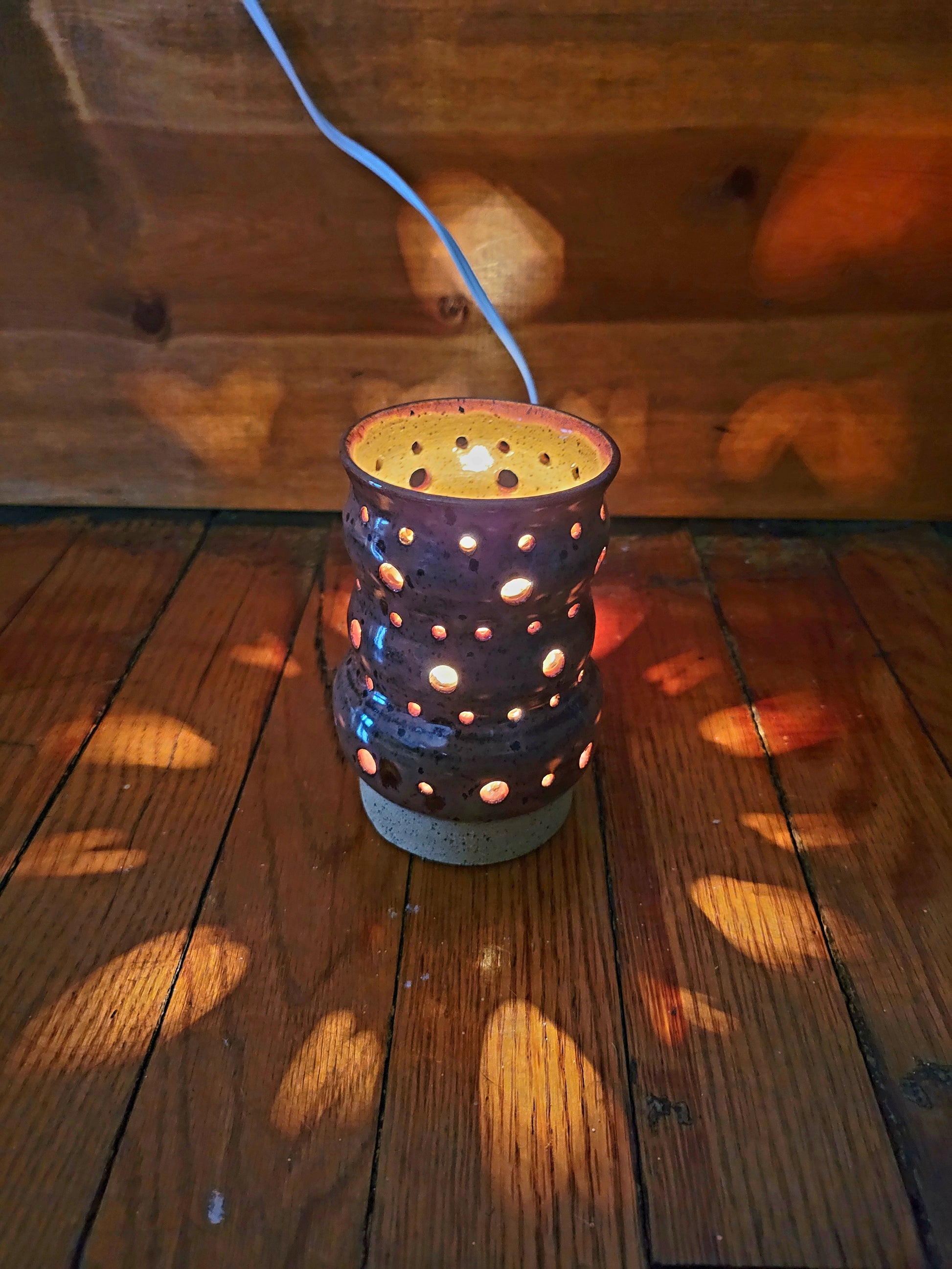Decorative lantern with holes on a wooden surface