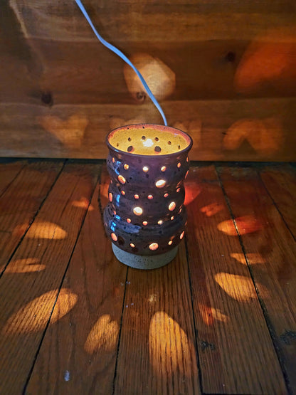 Decorative lantern with holes on a wooden surface